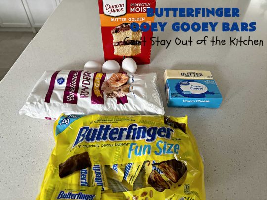 Butterfinger Ooey Gooey Bars | Can't Stay Out of the Kitchen | these lovely #OoeyGooeyBars include a #Cheesecake filling with chopped #Butterfingers on top! This easy 6-ingredient #recipe is so irresistible everyone will want seconds. They are out of this world good & will have you swooning from the first bite. Excellent for #tailgating, potlucks & a #ChristmasCookieExchange. #cookie #brownie #dessert #ButterfingerDessert #ButterfingerOoeyGooeyBars
