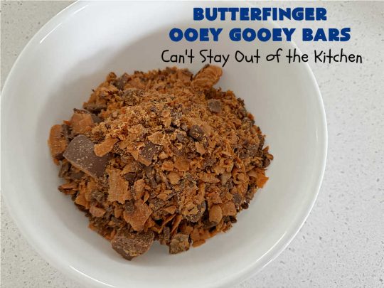 Butterfinger Ooey Gooey Bars | Can't Stay Out of the Kitchen | these lovely #OoeyGooeyBars include a #Cheesecake filling with chopped #Butterfingers on top! This easy 6-ingredient #recipe is so irresistible everyone will want seconds. They are out of this world good & will have you swooning from the first bite. Excellent for #tailgating, potlucks & a #ChristmasCookieExchange. #cookie #brownie #dessert #ButterfingerDessert #ButterfingerOoeyGooeyBars
