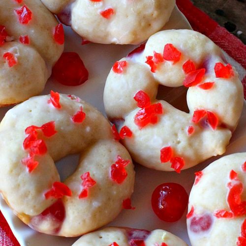 Cherry Almond Donuts | Can't Stay Out of the Kitchen | these luscious #donuts are filled with #cherries & #almond extract. They're glazed with an almond-flavored powdered sugar icing & topped with chopped cherries. Perfect for #ValentinesDay or any #holiday #breakfast. #HolidayBreakfast #ValentinesDayBreakfast #CherryDonuts #CherryAlmondDonuts