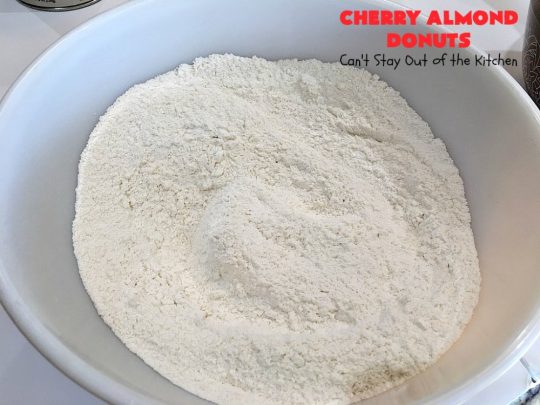 Cherry Almond Donuts | Can't Stay Out of the Kitchen | these luscious #donuts are filled with #cherries & #almond extract. They're glazed with an almond-flavored powdered sugar icing & topped with chopped cherries. Perfect for #ValentinesDay or any #holiday #breakfast. #HolidayBreakfast #ValentinesDayBreakfast #CherryDonuts #CherryAlmondDonuts 