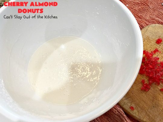 Cherry Almond Donuts | Can't Stay Out of the Kitchen | these luscious #donuts are filled with #cherries & #almond extract. They're glazed with an almond-flavored powdered sugar icing & topped with chopped cherries. Perfect for #ValentinesDay or any #holiday #breakfast. #HolidayBreakfast #ValentinesDayBreakfast #CherryDonuts #CherryAlmondDonuts 