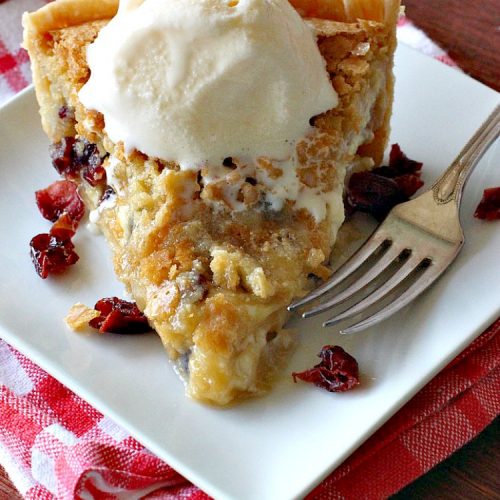 Cranberry White Chocolate Macadamia Nut Pie | Can't Stay Out of the Kitchen | this irresistible #pie is made with dried #cranberries, #MacadamiaNuts & #WhiteChocolateChips. It's so rich & decadent you'll be hooked from your first bite. Wonderful for #holiday parties and #Christmas dinner menus. #chocolate #dessert #Craisins #HolidayDessert #ChocolateDessert #CranberryDessert #CranberryWhiteChocolateMacadamiaNutPie