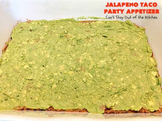 Jalapeno Taco Party Appetizer | Can't Stay Out of the Kitchen | the best #TexMex layered dip ever! This one uses refried beans with jalapenos, #avocados, a sour cream & #taco seasoning layer. Then it's topped with olives, #cheese, green onions and tomatoes. Perfect for #tailgating or #SuperBowl parties. #appetizer
