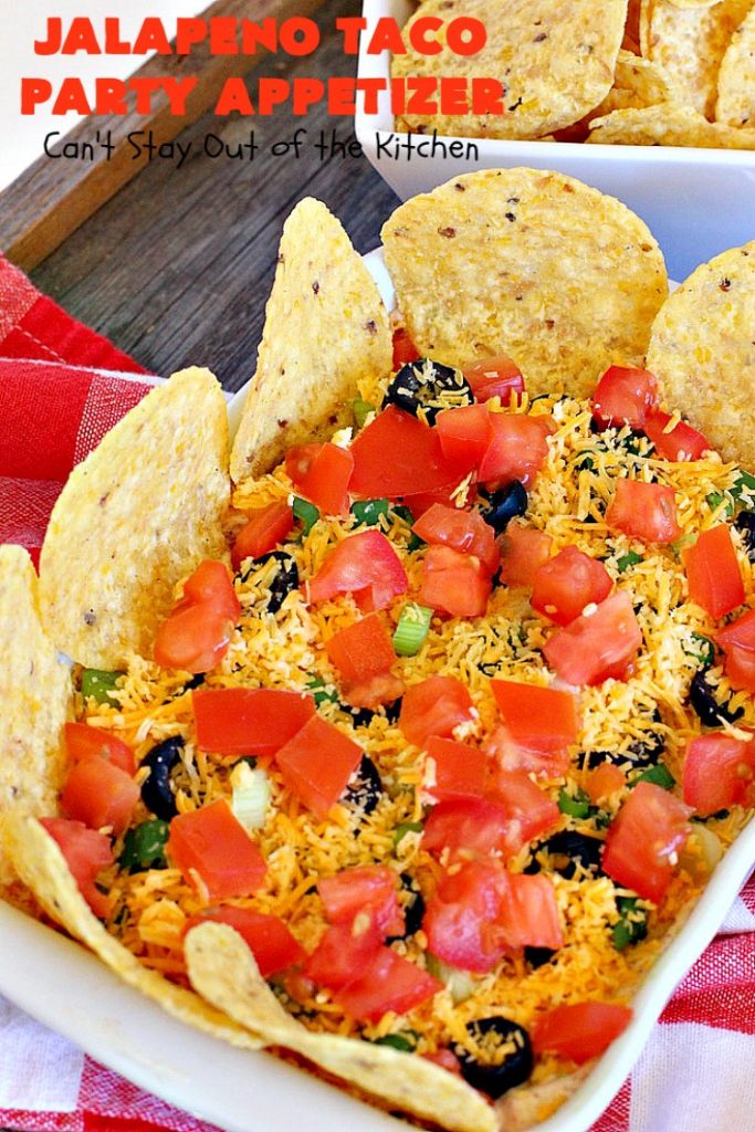 Jalapeno Taco Party Appetizer | Can't Stay Out of the Kitchen | the best #TexMex layered dip ever! This one uses refried beans with jalapenos, #avocados, a sour cream & #taco seasoning layer. Then it's topped with olives, #cheese, green onions and tomatoes. Perfect for #tailgating or #SuperBowl parties. #appetizer