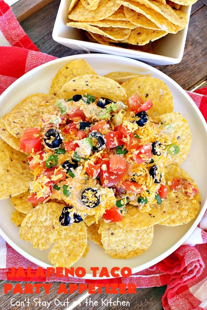Jalapeno Taco Party Appetizer | Can't Stay Out of the Kitchen | the best #TexMex layered dip ever! This one uses refried beans with jalapenos, #avocados, a sour cream & #taco seasoning layer. Then it's topped with olives, #cheese, green onions and tomatoes. Perfect for #tailgating or #SuperBowl parties. #appetizer