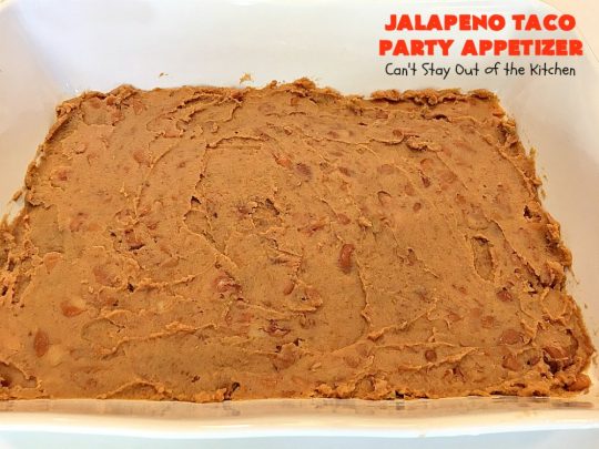 Jalapeno Taco Party Appetizer | Can't Stay Out of the Kitchen | the best #TexMex layered dip ever! This one uses refried beans with jalapenos, #avocados, a sour cream & #taco seasoning layer. Then it's topped with olives, #cheese, green onions and tomatoes. Perfect for #tailgating or #SuperBowl parties. #appetizer