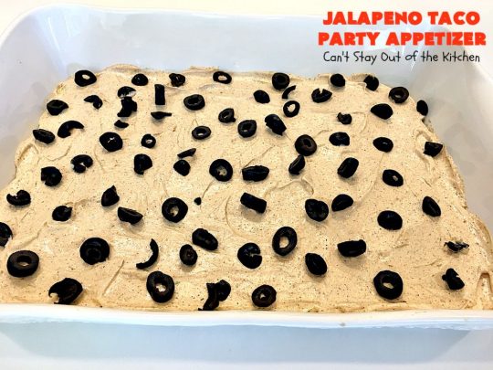Jalapeno Taco Party Appetizer | Can't Stay Out of the Kitchen | the best #TexMex layered dip ever! This one uses refried beans with jalapenos, #avocados, a sour cream & #taco seasoning layer. Then it's topped with olives, #cheese, green onions and tomatoes. Perfect for #tailgating or #SuperBowl parties. #appetizer