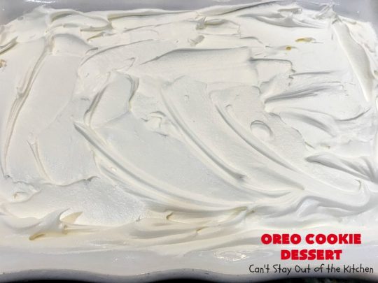 Oreo Cookie Dessert | Can't Stay Out of the Kitchen | This spectacular #dessert is rich, decadent & so addictive! No one will want only one piece! The bottom layer is crushed #Oreos. Layered with #BlueBell vanilla ice cream, then it has a homemade #fudge & walnut sauce. It's topped with #CoolWhip & more #Oreos. #OreoDessert #ChocolateDessert #IceCreamDessert #FudgeDessert #ValentinesDayDessert #HolidayDessert