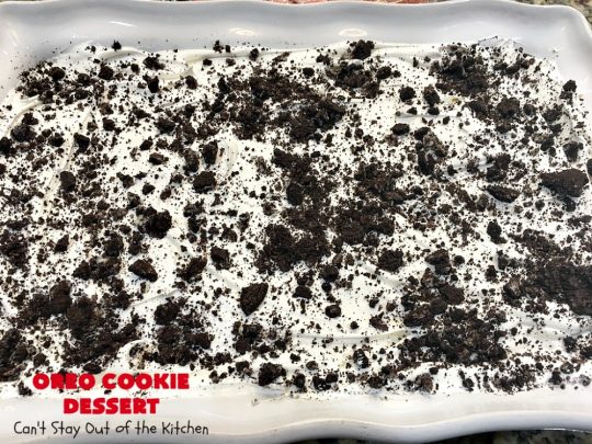 Oreo Cookie Dessert | Can't Stay Out of the Kitchen | This spectacular #dessert is rich, decadent & so addictive! No one will want only one piece! The bottom layer is crushed #Oreos. Layered with #BlueBell vanilla ice cream, then it has a homemade #fudge & walnut sauce. It's topped with #CoolWhip & more #Oreos. #OreoDessert #ChocolateDessert #IceCreamDessert #FudgeDessert #ValentinesDayDessert #HolidayDessert
