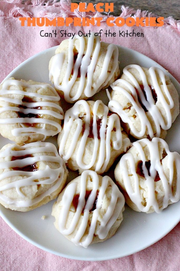 Peach Thumbprint Cookies | these fantastic little #cookies are terrific for #holiday #baking & #ChristmasCookieExchanges. They're filled with #peach jam & iced with a heavenly vanilla powdered sugar icing. #dessert #holiday #HolidayDessert ChristmasDessert #ChristmasCookie #PeachDessert #ThumbprintCookie