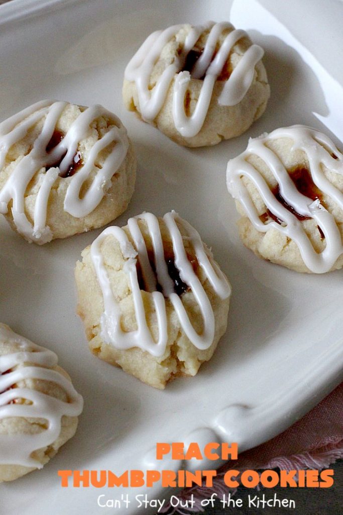Peach Thumbprint Cookies | these fantastic little #cookies are terrific for #holiday #baking & #ChristmasCookieExchanges. They're filled with #peach jam & iced with a heavenly vanilla powdered sugar icing. #dessert #holiday #HolidayDessert ChristmasDessert #ChristmasCookie #PeachDessert #ThumbprintCookie