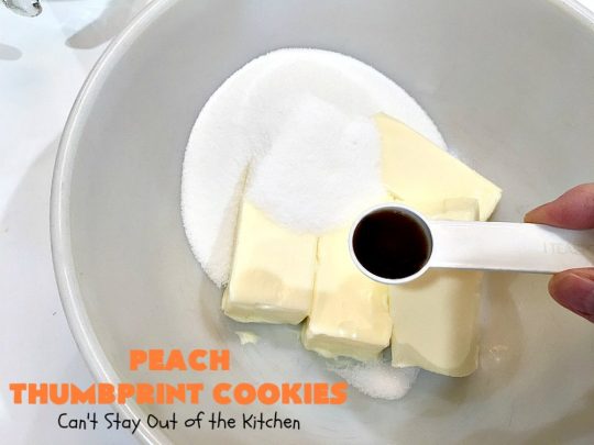 Peach Thumbprint Cookies | these fantastic little #cookies are terrific for #holiday #baking & #ChristmasCookieExchanges. They're filled with #peach jam & iced with a heavenly vanilla powdered sugar icing. #dessert #holiday #HolidayDessert ChristmasDessert #ChristmasCookie #PeachDessert #ThumbprintCookie