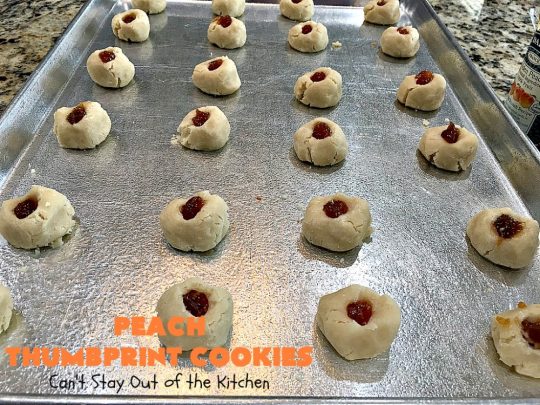 Peach Thumbprint Cookies | these fantastic little #cookies are terrific for #holiday #baking & #ChristmasCookieExchanges. They're filled with #peach jam & iced with a heavenly vanilla powdered sugar icing. #dessert #holiday #HolidayDessert ChristmasDessert #ChristmasCookie #PeachDessert #ThumbprintCookie