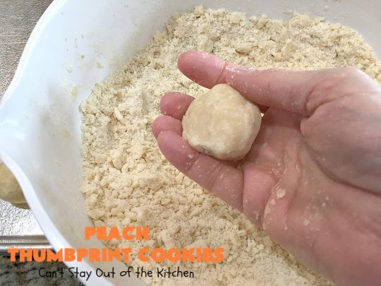 Peach Thumbprint Cookies | these fantastic little #cookies are terrific for #holiday #baking & #ChristmasCookieExchanges. They're filled with #peach jam & iced with a heavenly vanilla powdered sugar icing. #dessert #holiday #HolidayDessert ChristmasDessert #ChristmasCookie #PeachDessert #ThumbprintCookie
