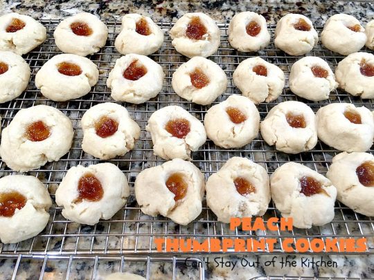 Peach Thumbprint Cookies | these fantastic little #cookies are terrific for #holiday #baking & #ChristmasCookieExchanges. They're filled with #peach jam & iced with a heavenly vanilla powdered sugar icing. #dessert #holiday #HolidayDessert ChristmasDessert #ChristmasCookie #PeachDessert #ThumbprintCookie