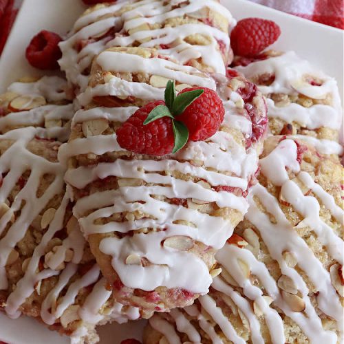 Raspberry Almond Scones | Can't Stay Out of the Kitchen | these delicious #scones are a perfect idea for a company or #holiday #breakfast, like #Thanksgiving or #Christmas. They're filled with fresh #raspberries, sliced #almonds & include #AlmondExtract in the batter as well as the icing. Every bite will rock your world! If you enjoy a sweet treat with your morning coffee, you'll love these! #RaspberryAlmondScones