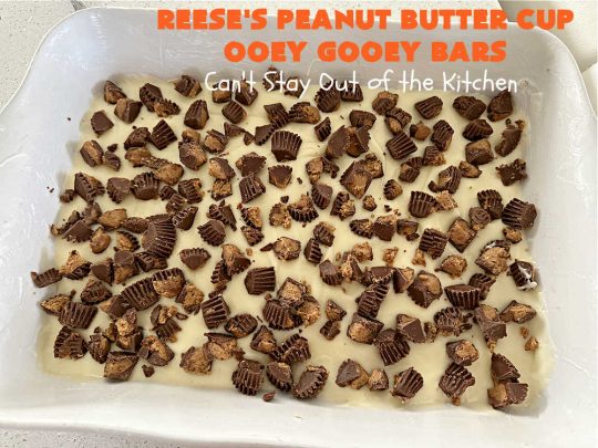 Reese's Peanut Butter Cup Ooey Gooey Bars | Can't Stay Out of the Kitchen | This fabulous #OoeyGooeyBar #recipe uses only 6 ingredients! It has a luscious #cheesecake filling & it's topped with #ReesesPeanutButterCups. Every bite will have you swooning! Great for #holiday #baking, #tailgating parties, a #ChristmasCookieExchange or any time you just need #chocolate! #PeanutButter #dessert #brownie #cookie #CreamCheese #ReesesPeanutButterCupOoeyGooeyBars
