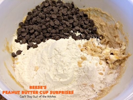 Reese's Peanut Butter Cup Surprises | Can't Stay Out of the Kitchen | these awesome #brownies have #ReesesPeanutButterCups tucked away between two layers of #MrsFieldsChocolateChipCookie dough. They are rich, decadent & absolutely heavenly. Perfect for #tailgating parties, a company #dessert or a #ChristmasCookieExchange. #PeanutButter #PeanutButterCups #chocolate #ReesesPeanutButterCupSurprises