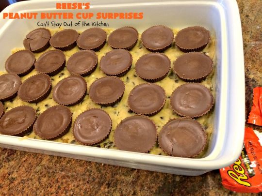 Reese's Peanut Butter Cup Surprises | Can't Stay Out of the Kitchen | these awesome #brownies have #ReesesPeanutButterCups tucked away between two layers of #MrsFieldsChocolateChipCookie dough. They are rich, decadent & absolutely heavenly. Perfect for #tailgating parties, a company #dessert or a #ChristmasCookieExchange. #PeanutButter #PeanutButterCups #chocolate #ReesesPeanutButterCupSurprises