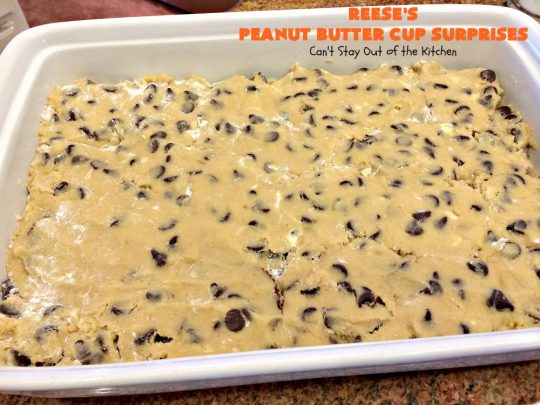 Reese's Peanut Butter Cup Surprises | Can't Stay Out of the Kitchen | these awesome #brownies have #ReesesPeanutButterCups tucked away between two layers of #MrsFieldsChocolateChipCookie dough. They are rich, decadent & absolutely heavenly. Perfect for #tailgating parties, a company #dessert or a #ChristmasCookieExchange. #PeanutButter #PeanutButterCups #chocolate #ReesesPeanutButterCupSurprises