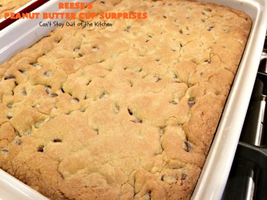 Reese's Peanut Butter Cup Surprises | Can't Stay Out of the Kitchen | these awesome #brownies have #ReesesPeanutButterCups tucked away between two layers of #MrsFieldsChocolateChipCookie dough. They are rich, decadent & absolutely heavenly. Perfect for #tailgating parties, a company #dessert or a #ChristmasCookieExchange. #PeanutButter #PeanutButterCups #chocolate #ReesesPeanutButterCupSurprises