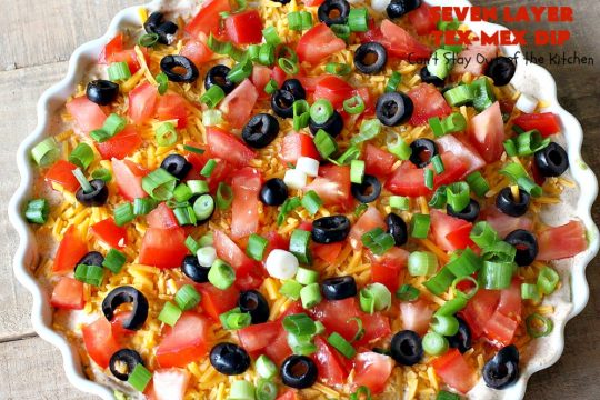 Seven Layer Tex-Mex Dip | Can't Stay Out of the Kitchen | this awesome #TexMex #dip is out of this world. It's terrific for any kind of company or #holiday party. We like it for #tailgating parties & potlucks. Also great for summer #holidays like #FourthOfJuly. #GlutenFree #Mexican #TexMexDip #LayeredMexicanDip #RefriedBeans #Jalapenos #Olives #CheddarCheese #Guacamole #TortillaChips #tomatoes #Avocados #SevenLayerTexMexDip #appetizer #TexMexAppetizer
