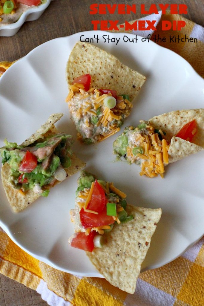 Seven Layer Tex-Mex Dip | Can't Stay Out of the Kitchen | this awesome #TexMex #dip is out of this world. It's terrific for any kind of company or #holiday party. We like it for #tailgating parties & potlucks. Also great for summer #holidays like #FourthOfJuly. #GlutenFree #Mexican #TexMexDip #LayeredMexicanDip #RefriedBeans #Jalapenos #Olives #CheddarCheese #Guacamole #TortillaChips #tomatoes #Avocados #SevenLayerTexMexDip #appetizer #TexMexAppetizer