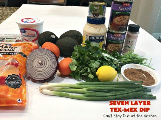 Seven Layer Tex-Mex Dip | Can't Stay Out of the Kitchen | this awesome #TexMex #dip is out of this world. It's terrific for any kind of company or #holiday party. We like it for #tailgating parties & potlucks. Also great for summer #holidays like #FourthOfJuly. #GlutenFree #Mexican #TexMexDip #LayeredMexicanDip #RefriedBeans #Jalapenos #Olives #CheddarCheese #Guacamole #TortillaChips #tomatoes #Avocados #SevenLayerTexMexDip #appetizer #TexMexAppetizer