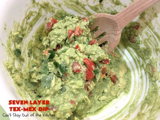 Seven Layer Tex-Mex Dip | Can't Stay Out of the Kitchen | this awesome #TexMex #dip is out of this world. It's terrific for any kind of company or #holiday party. We like it for #tailgating parties & potlucks. Also great for summer #holidays like #FourthOfJuly. #GlutenFree #Mexican #TexMexDip #LayeredMexicanDip #RefriedBeans #Jalapenos #Olives #CheddarCheese #Guacamole #TortillaChips #tomatoes #Avocados #SevenLayerTexMexDip #appetizer #TexMexAppetizer