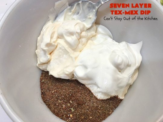 Seven Layer Tex-Mex Dip | Can't Stay Out of the Kitchen | this awesome #TexMex #dip is out of this world. It's terrific for any kind of company or #holiday party. We like it for #tailgating parties & potlucks. Also great for summer #holidays like #FourthOfJuly. #GlutenFree #Mexican #TexMexDip #LayeredMexicanDip #RefriedBeans #Jalapenos #Olives #CheddarCheese #Guacamole #TortillaChips #tomatoes #Avocados #SevenLayerTexMexDip #appetizer #TexMexAppetizer