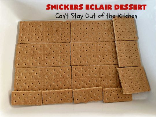 Snickers Éclair Dessert | Can't Stay Out of the Kitchen | this easy-peasy 6-ingredient #recipe is spectacular for company, potlucks or special occasions like #ValentinesDay. It includes layers of #ChocolatePudding, #GrahamCrackers, #ChocolateIcing and #SnickersCandyBars on top. The #Snickers give it that wonderful chocolaty & #caramel flavor along with #peanuts that adds a little punch to the #dessert. So easy even a child can make it! #Éclairs #ÉclairDessert #SnickersÉclairDessert