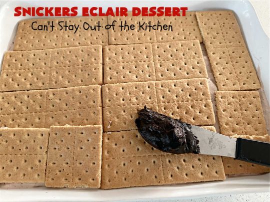 Snickers Éclair Dessert | Can't Stay Out of the Kitchen | this easy-peasy 6-ingredient #recipe is spectacular for company, potlucks or special occasions like #ValentinesDay. It includes layers of #ChocolatePudding, #GrahamCrackers, #ChocolateIcing and #SnickersCandyBars on top. The #Snickers give it that wonderful chocolaty & #caramel flavor along with #peanuts that adds a little punch to the #dessert. So easy even a child can make it! #Éclairs #ÉclairDessert #SnickersÉclairDessert