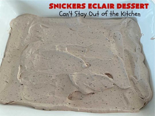 Snickers Éclair Dessert | Can't Stay Out of the Kitchen | this easy-peasy 6-ingredient #recipe is spectacular for company, potlucks or special occasions like #ValentinesDay. It includes layers of #ChocolatePudding, #GrahamCrackers, #ChocolateIcing and #SnickersCandyBars on top. The #Snickers give it that wonderful chocolaty & #caramel flavor along with #peanuts that adds a little punch to the #dessert. So easy even a child can make it! #Éclairs #ÉclairDessert #SnickersÉclairDessert