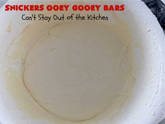 Snickers Ooey Gooey Bars | Can't Stay Out of the Kitchen | these luscious #OoeyGooeyBars contain a #cheesecake layer & they're topped with #SnickersBars for a lovely #chocolate & #PeanutButter flavor that will win over all your family & friends. This 6-ingredient #recipe is perfect for #tailgating parties, potlucks or a #ChristmasCookieExchange. It's easy to whip up & everyone loves them! #holiday #HolidayDessert #SnickersDessert #dessert #brownie #SnickersOoeyGooeyBars