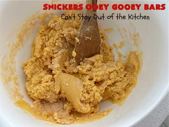 Snickers Ooey Gooey Bars | Can't Stay Out of the Kitchen | these luscious #OoeyGooeyBars contain a #cheesecake layer & they're topped with #SnickersBars for a lovely #chocolate & #PeanutButter flavor that will win over all your family & friends. This 6-ingredient #recipe is perfect for #tailgating parties, potlucks or a #ChristmasCookieExchange. It's easy to whip up & everyone loves them! #holiday #HolidayDessert #SnickersDessert #dessert #brownie #SnickersOoeyGooeyBars
