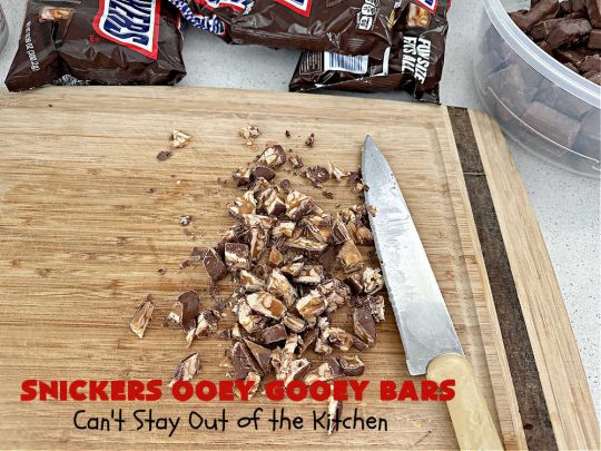 Snickers Ooey Gooey Bars | Can't Stay Out of the Kitchen | these luscious #OoeyGooeyBars contain a #cheesecake layer & they're topped with #SnickersBars for a lovely #chocolate & #PeanutButter flavor that will win over all your family & friends. This 6-ingredient #recipe is perfect for #tailgating parties, potlucks or a #ChristmasCookieExchange. It's easy to whip up & everyone loves them! #holiday #HolidayDessert #SnickersDessert #dessert #brownie #SnickersOoeyGooeyBars