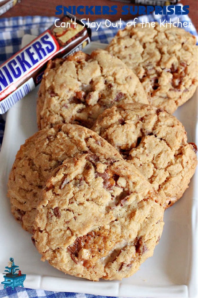 Snickers Surprises | Can't Stay Out of the Kitchen | these scrumptious #PeanutButterCookies include #SnickersBars so they have a little bit of #caramel, #chocolate & #PeanutButter in every bite. You're sure to swoon once you get a taste of these jewels. Perfect for #tailgating, potlucks, backyard BBQs and #holiday #baking. #ChristmasCookieExchange #dessert #ChocolateDessert #SnickersDessert #PeanutButterDessert #CaramelDessert #cookies #SnickersSurprises