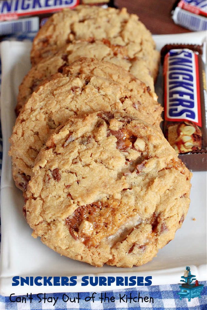 Snickers Surprises | Can't Stay Out of the Kitchen | these scrumptious #PeanutButterCookies include #SnickersBars so they have a little bit of #caramel, #chocolate & #PeanutButter in every bite. You're sure to swoon once you get a taste of these jewels. Perfect for #tailgating, potlucks, backyard BBQs and #holiday #baking. #ChristmasCookieExchange #dessert #ChocolateDessert #SnickersDessert #PeanutButterDessert #CaramelDessert #cookies #SnickersSurprises