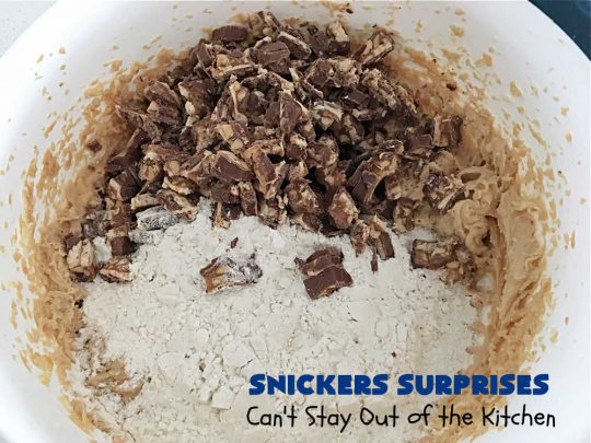 Snickers Surprises | Can't Stay Out of the Kitchen | these scrumptious #PeanutButterCookies include #SnickersBars so they have a little bit of #caramel, #chocolate & #PeanutButter in every bite. You're sure to swoon once you get a taste of these jewels. Perfect for #tailgating, potlucks, backyard BBQs and #holiday #baking. #ChristmasCookieExchange #dessert #ChocolateDessert #SnickersDessert #PeanutButterDessert #CaramelDessert #cookies #SnickersSurprises