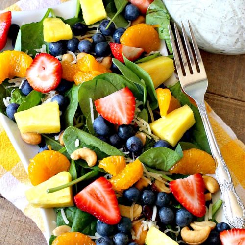 Spinach and Fruit Salad with Poppy Seed Dressing | this is one of our favorite #salad #recipes. It's filled with #strawberries, #Blueberries, #pineapple & #MandarinOranges. It also has #Cashews & #SwissCheese. No one can resist this amazing #TossedSalad! We serve it for company all the time. #holiday #HolidaySalad #TossedSaladWithFruit #SpinachSalad #SpinachAndFruitSaladWithPoppySeedDressing #PoppySeedDressing #GlutenFree #Healthy #HealthySaladRecipe